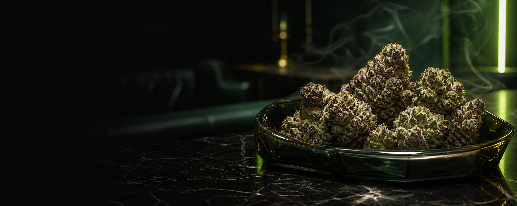 Premium cannabis flower arranged on a smoked-glass tray in a dark green lounge
